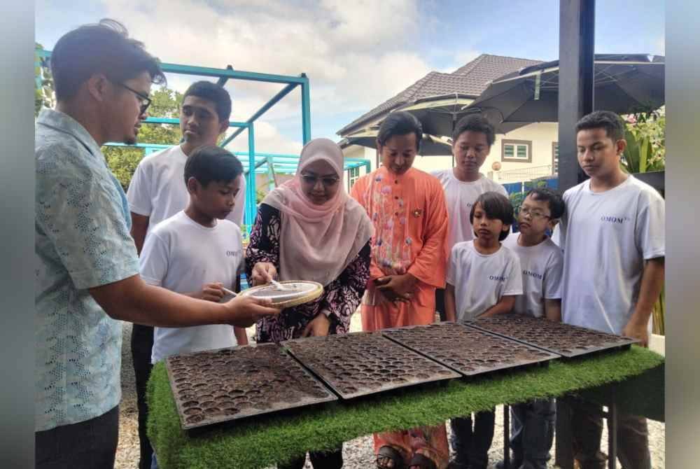 Wan Faizatul Aniza (lima, kanan) menanam benih sawi pada sempena perasmian Famazara Agro Educare sebagai Pusat Rujukan Pertanian Untuk Kanak-Kanak Istimewa pada Ahad.