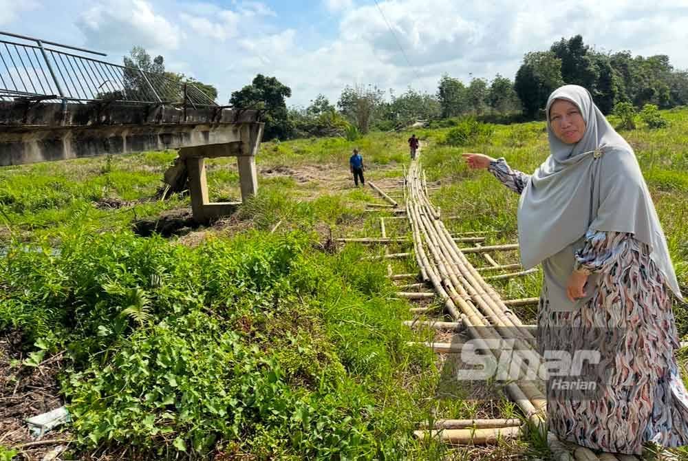 Siti Zailah (kanan) turut turun padang melihat keadaan titi yang digunakan penduduk. FOTO SINAR HARIAN-ADILA SHARINNI WAHID
