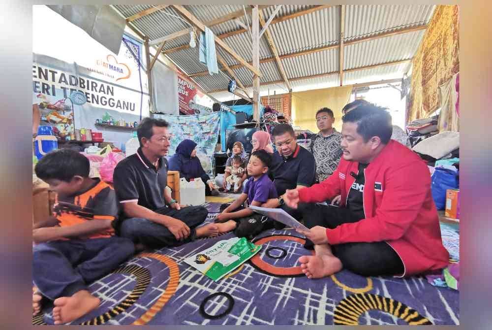 Mohd Hasbie (kanan) bersama Zulkifli (dua dari kanan) ketika menziarahi keluarga itu di Kampung Darat Batu Rakit di Kuala Nerus.
