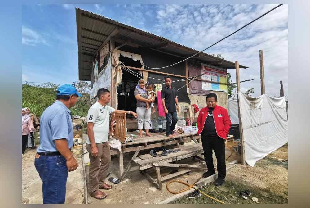 Jani (dua dari kanan) ketika menerima kunjungan Mohd Hasbie dan Zulkifli di rumah usang yang dididaminya bersama isteri dan tiga anak.
