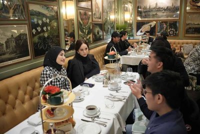 Adzliana (kiri) beramah mesra bersama para pelajar Malaysia ketika majlis minum petang di
Oxford.