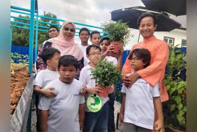 Wan Faizatul Aniza (kiri) bersama kanak-kanak Bizara sempena perasmian Famazara Agro Educare sebagai Pusat Rujukan Pertanian Untuk Kanak-Kanak Istimewa pada Ahad.