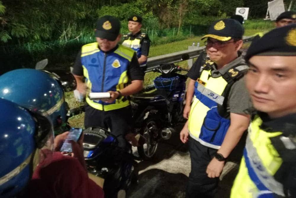 Azrin (dua, kanan) memeriksa salah sebuah motosikal yang ditahan dalam Operasi Khas Tahun Baharu Cina peringkat Selangor di Plaza Tol Lebuhraya Kajang SILK pada Ahad.