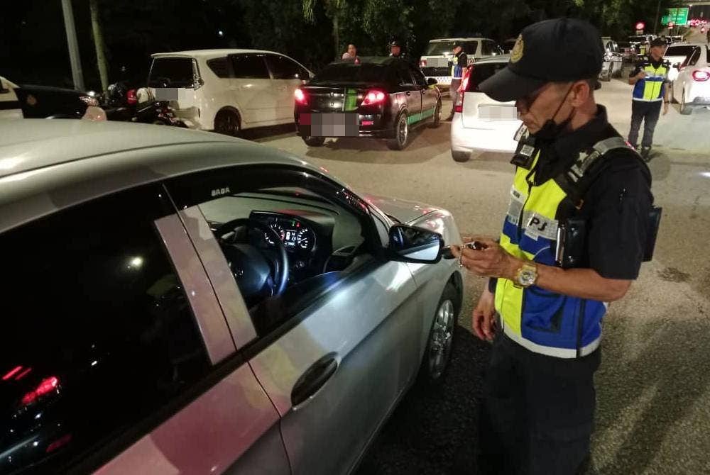 Anggota JPJ melakukan pemeriksaan terhadap kenderaan dalam Operasi Khas Tahun Baharu Cina peringkat Selangor di Plaza Tol Lebuhraya Kajang SILK pada Ahad.