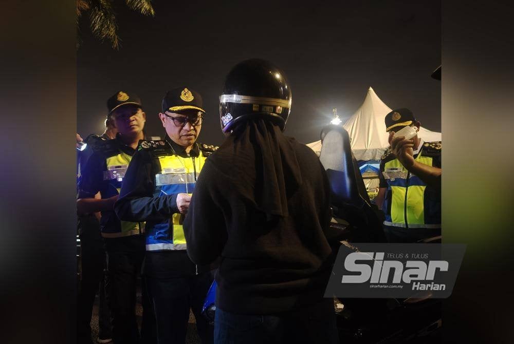 Aedy Fadly melakukan pemeriksaan ke atas penunggang motosikal semasa Op Khas Tahun Baharu Cina di Plaza Tol Sungai Besi, Kuala Lumpur pada Ahad.