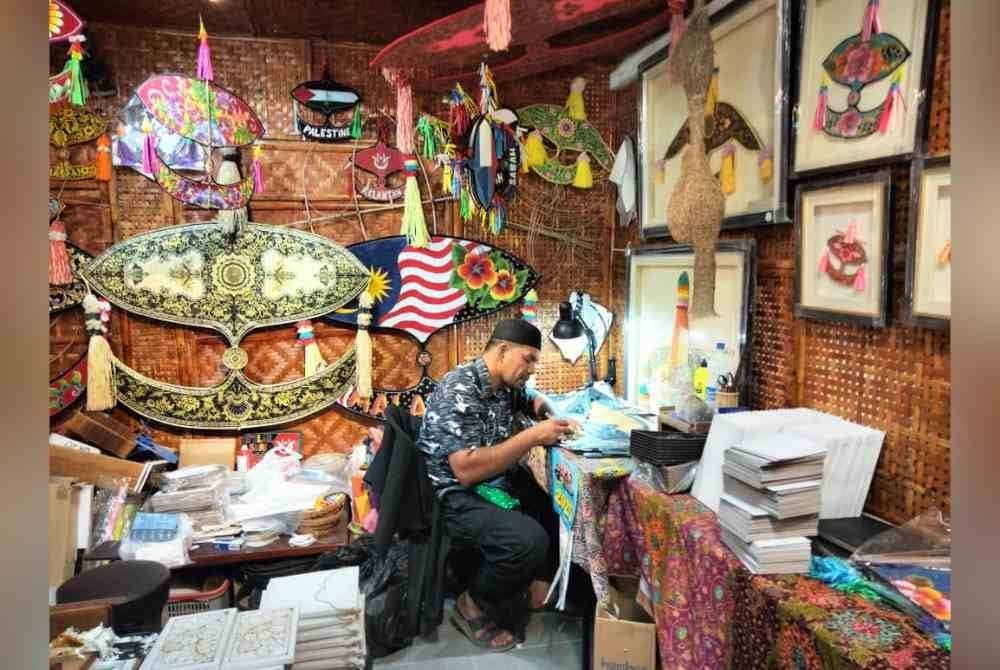 Megat Mayusif membuat wau sobek di galeri wau di Laman Warisan.