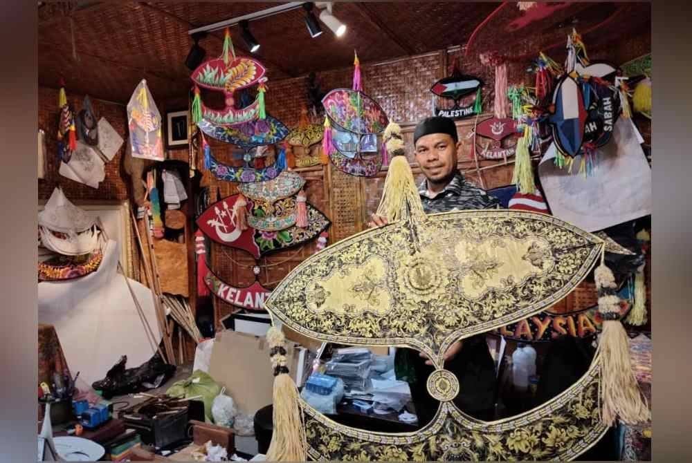 Megat Mayusif menunjukkan wau sobek berusia lebih 22 tahun lalu.