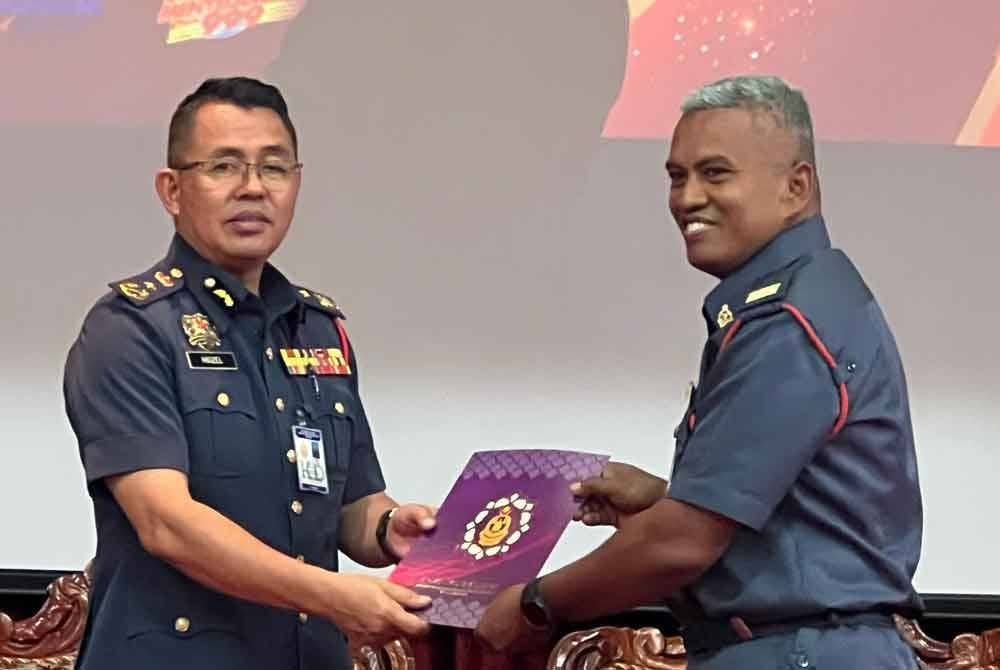 Awang Hidzel (kiri) menyampaikan sijil penyertaan program ‘wellness hub’ kepada anggota JBPM Kedah pada Isnin.