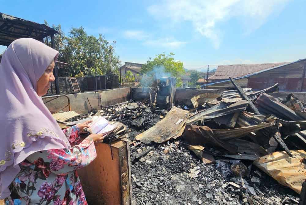Zaliha merenung keadaan rumahnya yang hangus terbakar dalam kejadian di Kampung Tengku Hussein Baru, Gugusan Manjoi di sini.