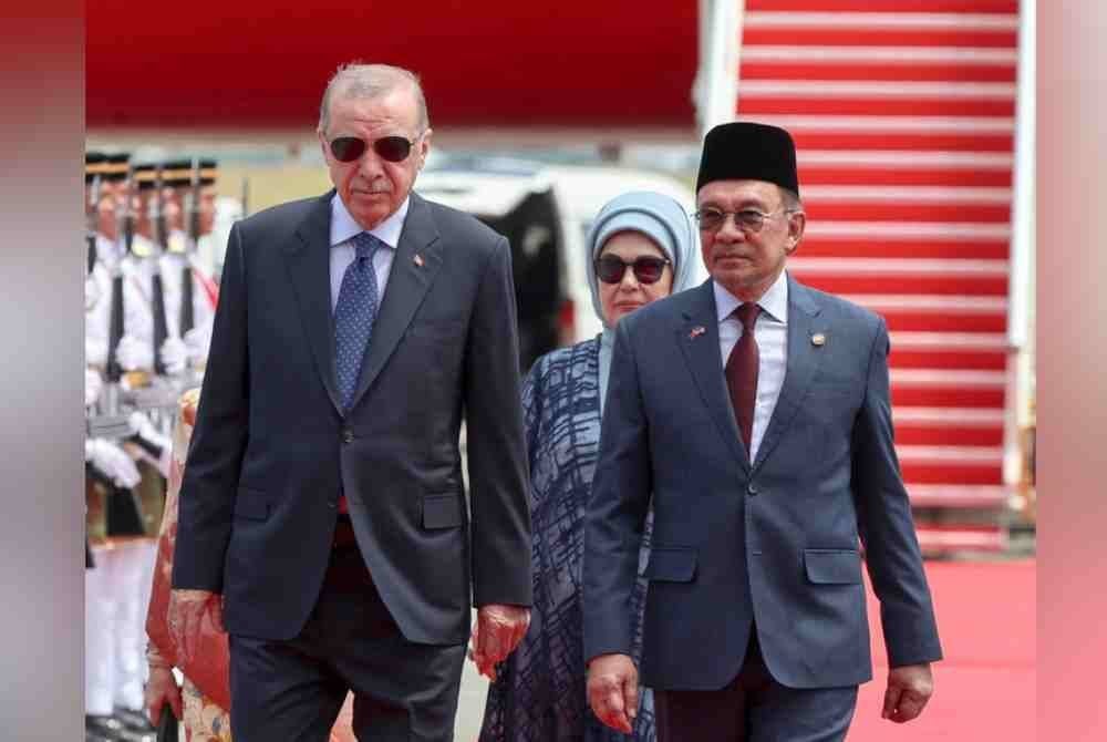 Anwar (kanan) mengiringi Erdogan memeriksa barisan kawalan kehormatan oleh 28 pegawai dan anggota dari Batalion Pertama Rejimen Renjer Diraja (Istiadat) di Kompleks Bunga Raya Lapangan Terbang Antarabangsa Kuala Lumpur (KLIA), hari ini. - Foto Bernama