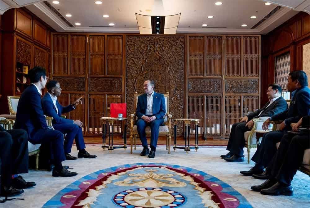 Anwar (depan) menerima hormat daripada Naib Presiden Eksekutif dan Ketua Pegawai Komersial Arm Limited, Will Abbey (kiri) yang turut disertai Rafizi (kanan). Foto FB Anwar