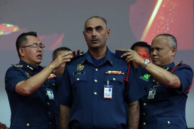 Awang Hidzel (kiri) memakaikan pangkat kepada anggota JBPM Kedah di Ibu Pejabat JBPM pada Isnin.