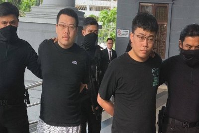 Chun Ta (dua dari kiri) dan Ming Hung (dua dari kanan) dibawa ke Mahkamah Sesyen Kuala Lumpur pada Isnin, bagi menghadapi tiga pertuduhan memperdagangkan dan memiliki senjata api pada bulan lalu.