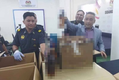 Mohd Sabri (kanan) menunjukkan minuman keras tiruan yang dirampas.