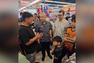 Razali (kiri) mengambil peluang berkongsi pandangan dengan Menteri Perdagangan Dalam Negeri dan Kos Sara Hidup, Datuk Armizan Mohd Ali (tengah) berkenaan manfaat yang diterima susulan pelaksanaan PJRM 'Back To School ' di Penampang.