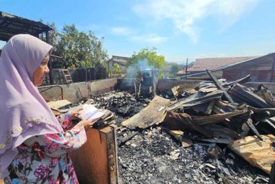 Zaliha merenung keadaan rumahnya yang hangus terbakar dalam kejadian di Kampung Tengku Hussein Baru, Gugusan Manjoi di sini.