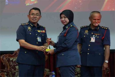Awang Hidzel (kiri) menyampaikan anugerah figura integriti JBPM Kedah kepada Pegawai Keselamatan Kebakaran, Zon 3 (Kulim), Penolong Kanan Penguasa Bomba, Nor Basiroh Mazlan pada Isnin.
