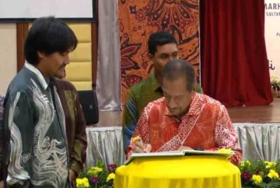 Sultan Mizan menandatangani buku mewah bertajuk 'Permata Negeri Terengganu: Setiu Wetlands' di sebuah hotel pada Isnin.