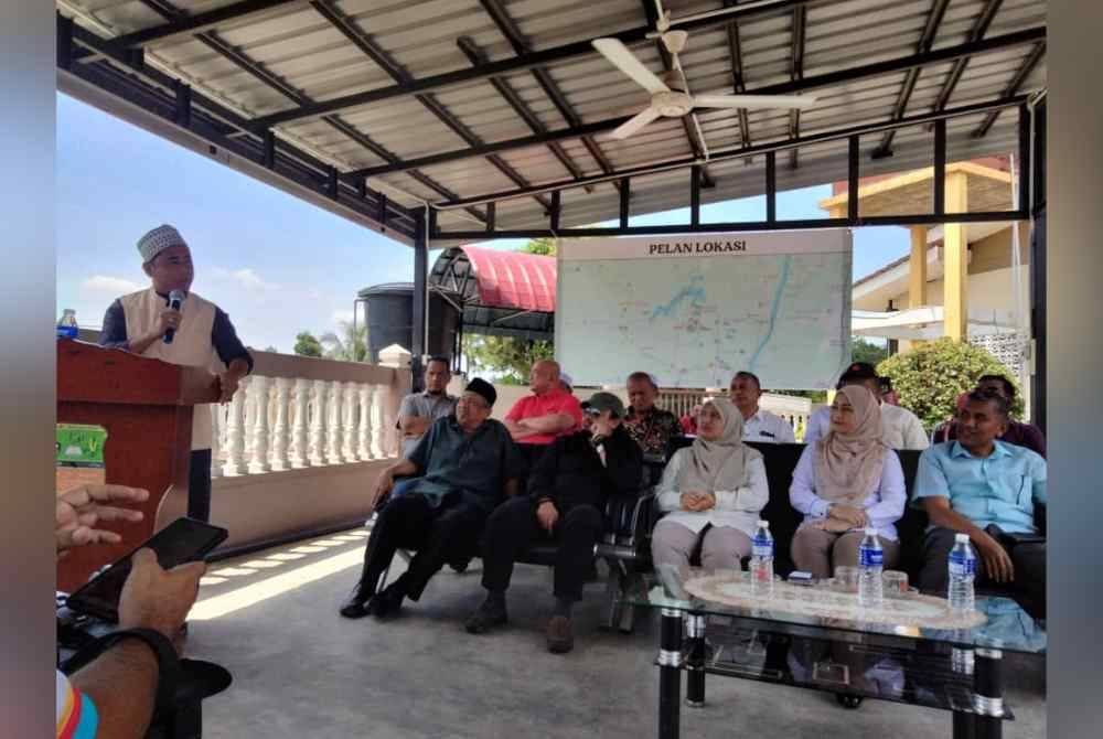 Siti Fairus (duduk dua dari kanan) bersama penduduk Kampung Rong Chenok selepas meninjau kawasan jambatan runtuh.