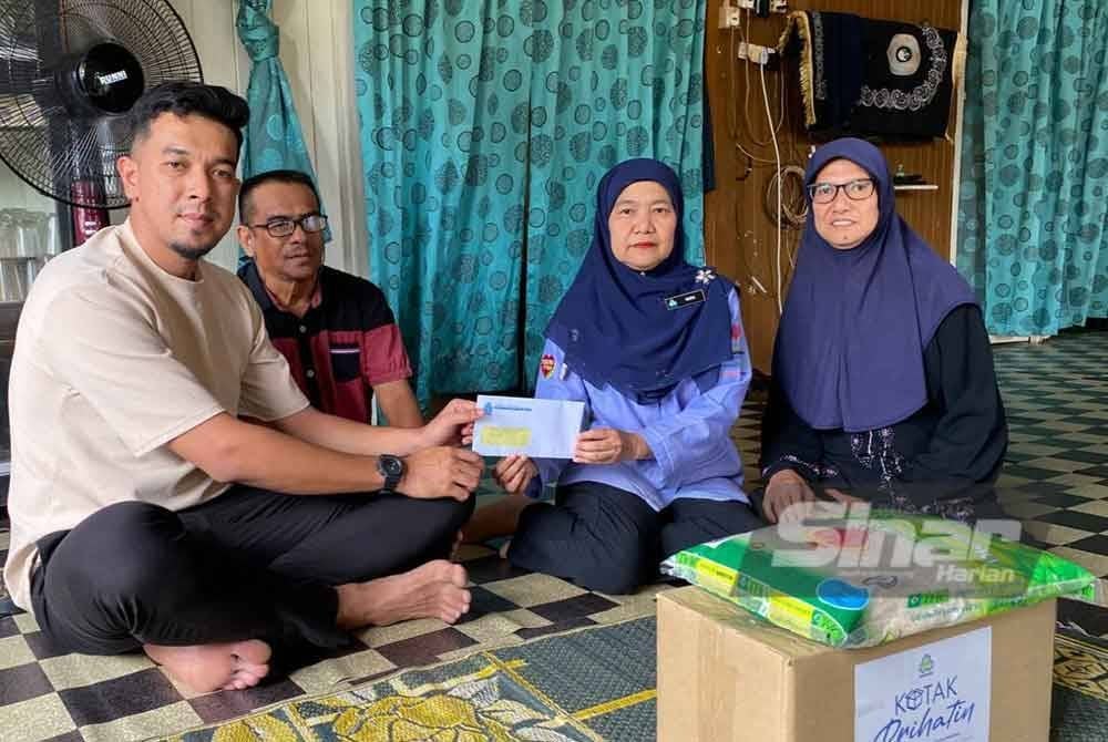 Muhammad Syahmi (kiri) menyerahkan pencen penakat PERKESO berjumlah RM470 sebulan kepada ibu mentuanya.