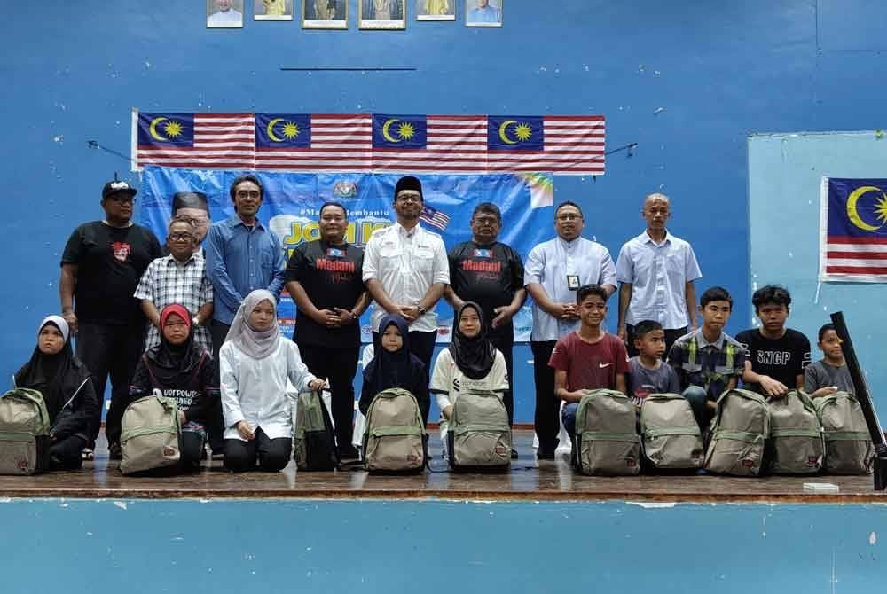 Zulkifli (empat dari kanan) bergambar bersama penerima pada gimik perasmian Jom Kembali ke Sekolah 2025 pada Selasa.