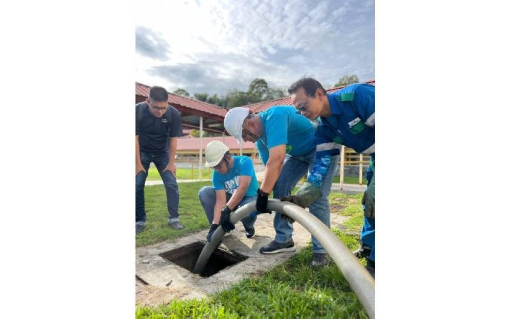 Narendran dibantu oleh Ketua Pegawai Operasi IWK, Mohd Taufik Salleh melakukan pengosongan tangki septik individu.