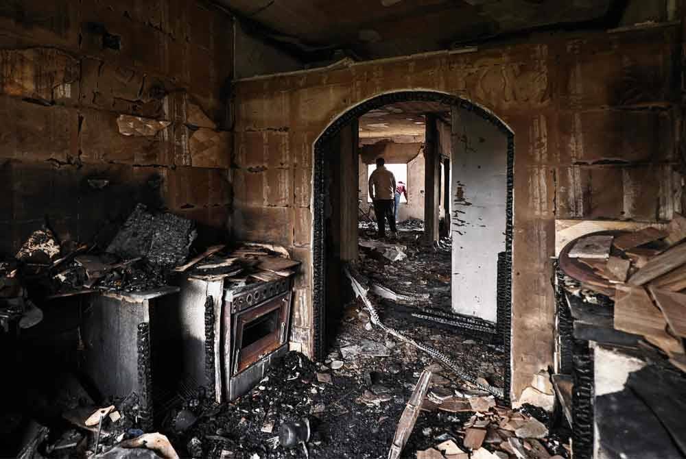 Penduduk Palestin memeriksa kemusnahan bangunan susulan serangan askar IDF di Tebing Barat. Foto AFP