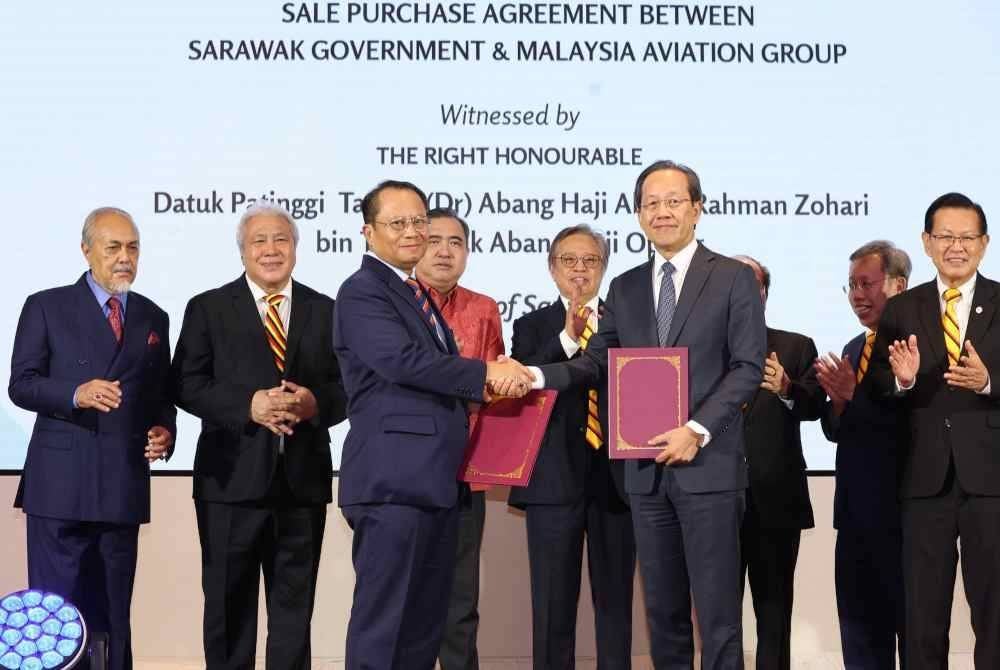 Abang Johari (lima dari kiri) dan Anthony Loke (empat dari kiri) menyaksikan pertukaran perjanjian antara Amar Mohamad (tiga dan kiri) dengan Izham pada Rabu. Foto Bernama