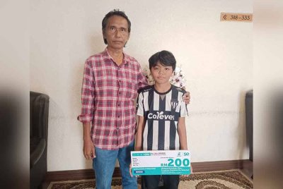 Muhammad Khawarizmi (kanan) antara 200 murid daripada keluarga berpendapatan rendah (B40) menerima sumbangan menerusi program Back To School 2025 anjuran Petronas.