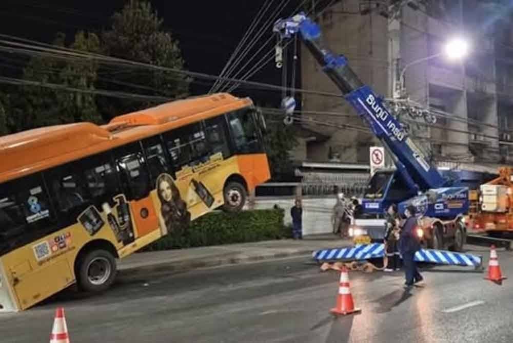 Bas ditarik oleh kren besar untuk mengangkat dan mengeluarkan bas daripada kabel tiang elektrik tersebut.