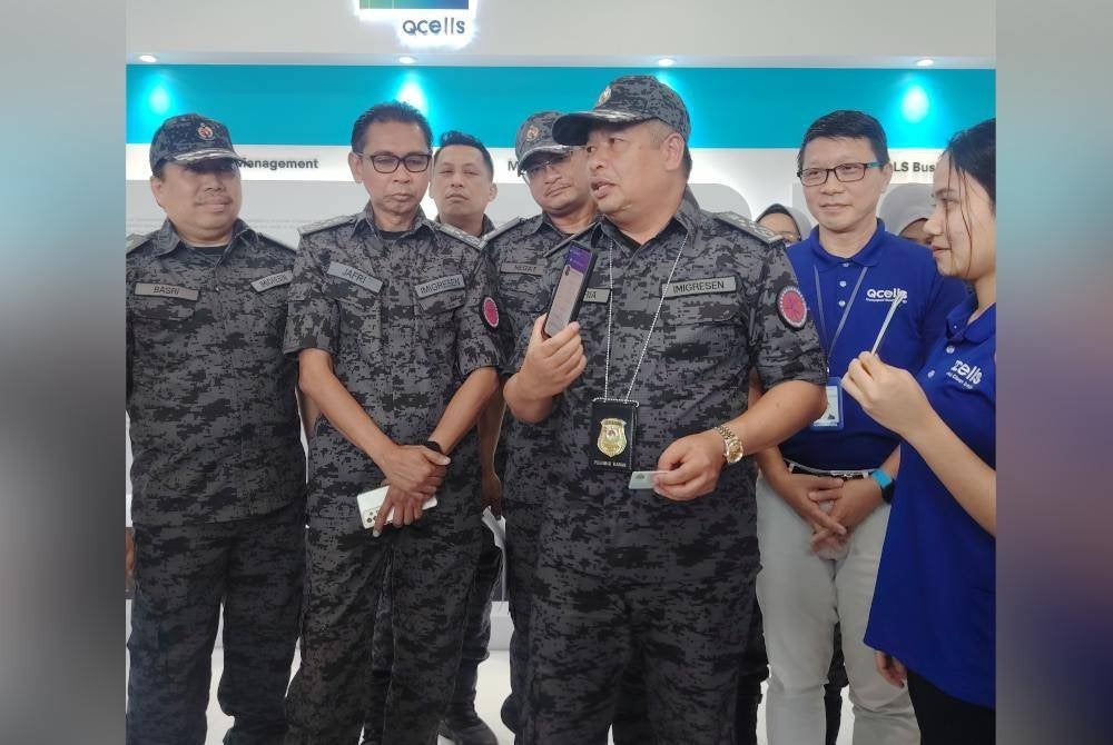 Zakaria (tengah) menunjukkan antara kaedah pemeriksaan baharu terhadap warga asing secara digital yang dilaksanakan JIM.