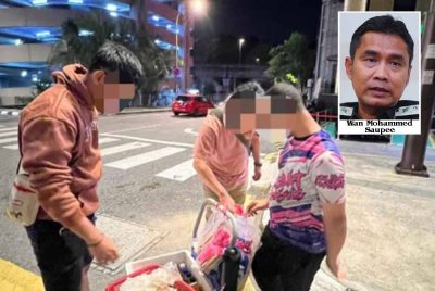 JIM menahan penjaja 'rambo' warga Bangladesh di Jalan Raja Laut, Kuala Lumpur pada Khamis.