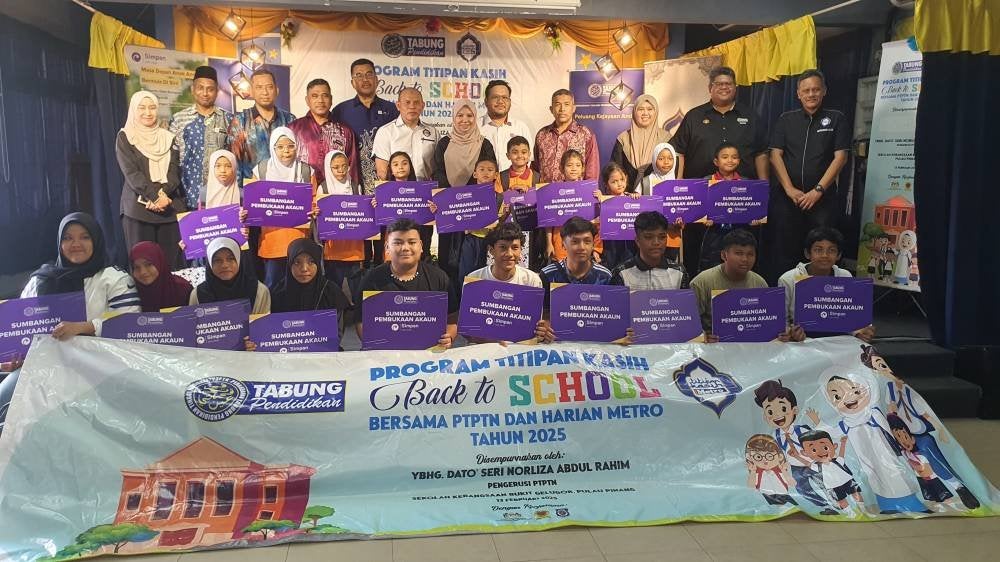 Norliza (tengah) bergambar bersama sebahagian penerima bantuan Program Titipan Kasih Back To School yang diadakan di SK Bukit Gelugor, pada Khamis.