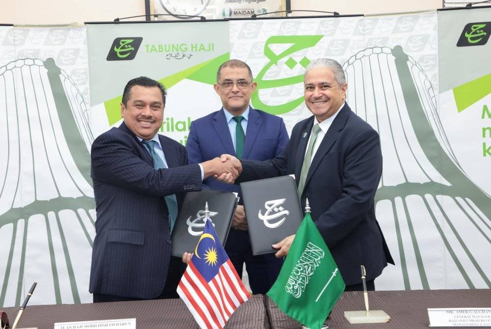 Syed Hamadah (tengah) bersama Mohd Hisham (kiri) dan Amer (kanan) ketika Majlis Menandatangani Perjanjian penyediaan penerbangan jemaah haji Malaysia.