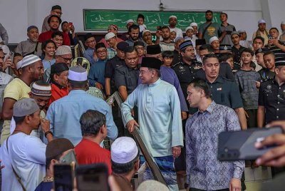 Anwar bertanyakan sesuatu pada salah seorang jemaah selepas menunaikan solat Jumaat di Masjid As-Salam, pada Jumaat. Foto Bernama