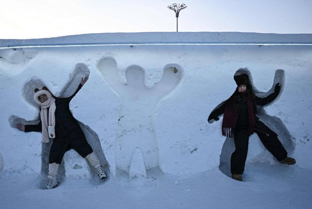 Gelagat dua pengunjung yang seronok bermain salji.