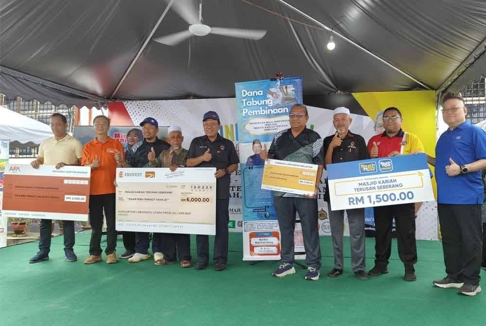 Sazali (empat dari kanan) dan Ismail (empat dari kiri) bersama rakan strategik yang menyumbang pada pelancaran tabung dana Bilik Pengurusan Jenazah Kampung Terusan Seberang.