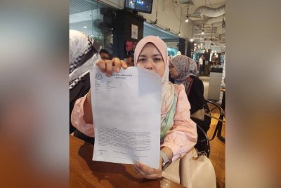 Siti Suwaibah menunjukkan laporan polis dibuatnya.