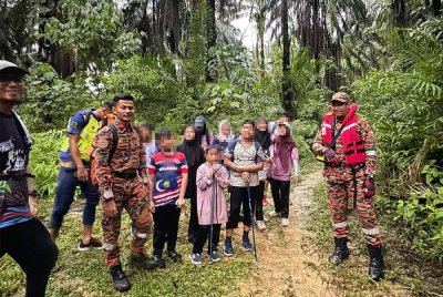 Anggota bomba bersama mangsa yang berjaya menyelamatkan diri selepas terperangkap dalam arus deras di Lata Perangin Muallim di sini pada Sabtu.