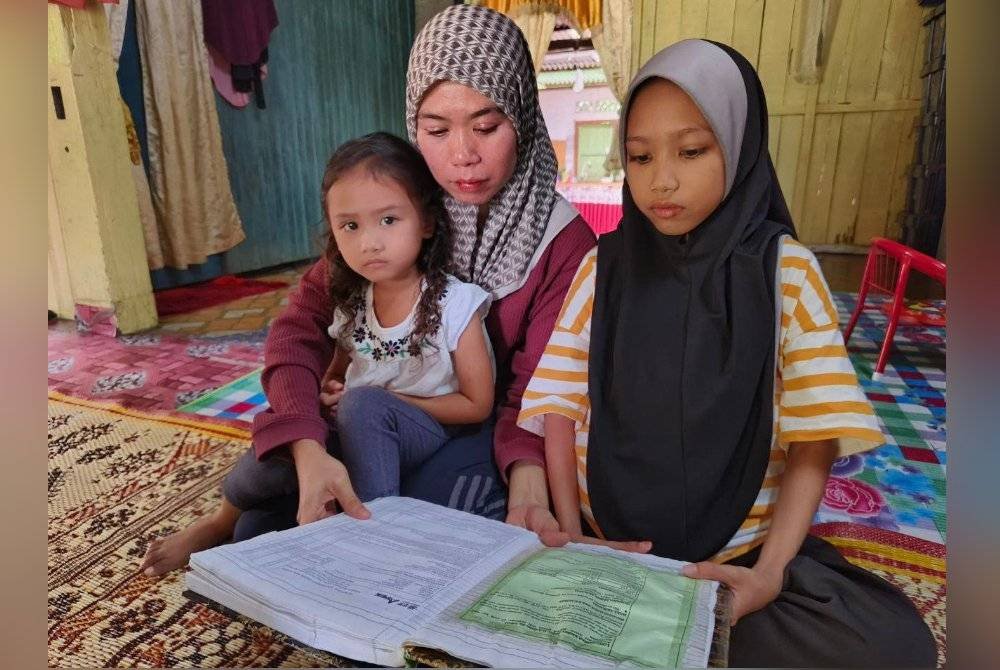 Nor Ariana (kanan) sentiasa mengulangkaji pelajaran walaupun tidak dapat hadir ke sekolah.