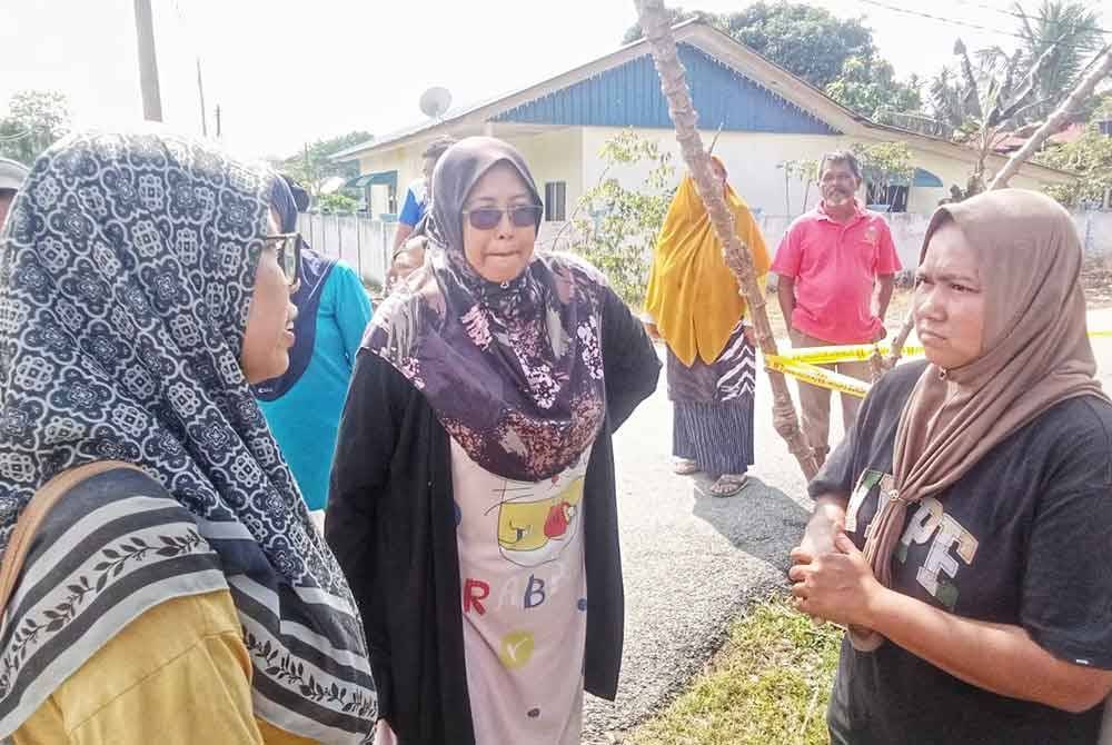 Norlin (kanan) ketika berada di lokasi melihat keadaan premis berkenaan.