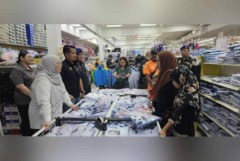 Fuziah sempat meninjau ibu bapa yang membeli pakaian sekolah di saat akhir sebelum sesi persekolahan bermula esok.