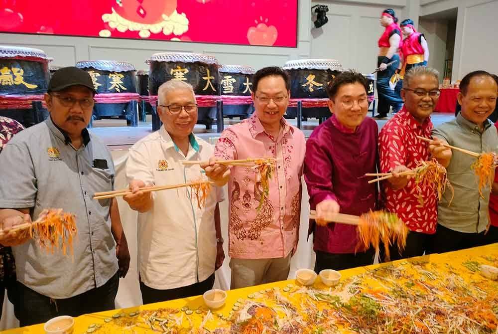 Wee Tse (empat dari kanan) menggaul Yee Sang pada Majlis Rumah Terbuka Tahun Baharu Cina Parlimen Tebrau bersama PKR Johor di Tebrau pada Ahad.