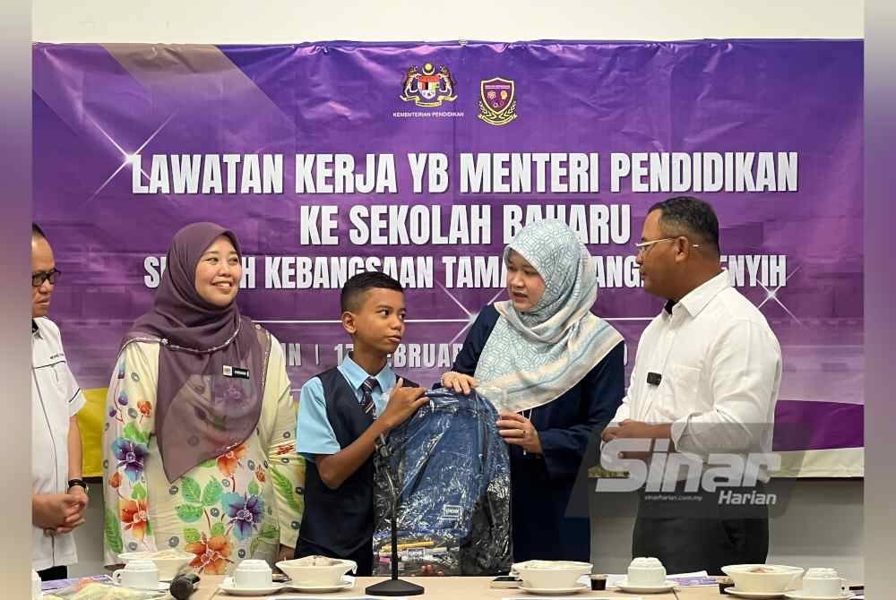 Fadhlina (dua dari kanan) bersama Amirudin (kanan) menyerahkan bantuan persekolahan kepada murid dari keluarga berpendapatan rendah (B40) pada hari pertama sesi persekolahan 2025.