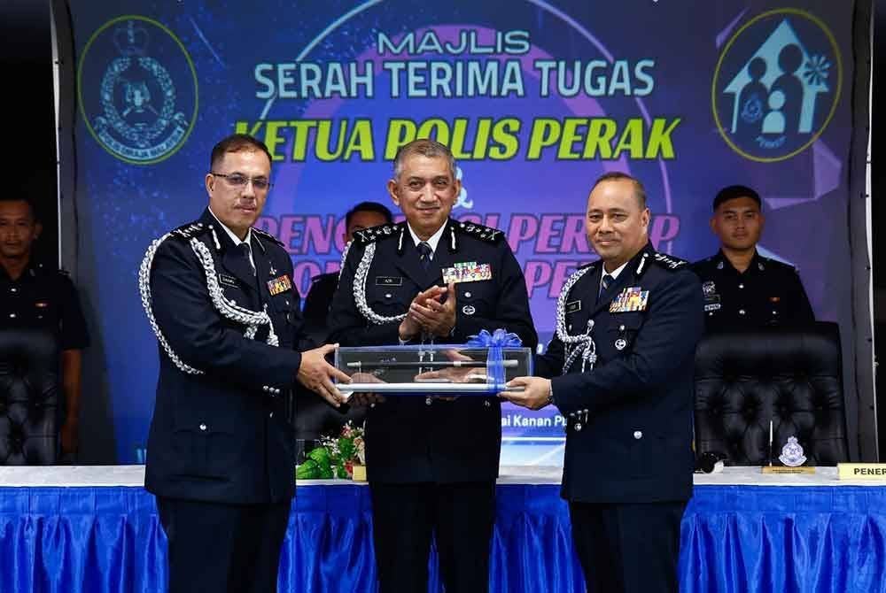 Azri (tengah) menyaksikan serah terima tugas Ketua Polis Perak antara Zulkafli (kiri) kepada Noor Hisam.