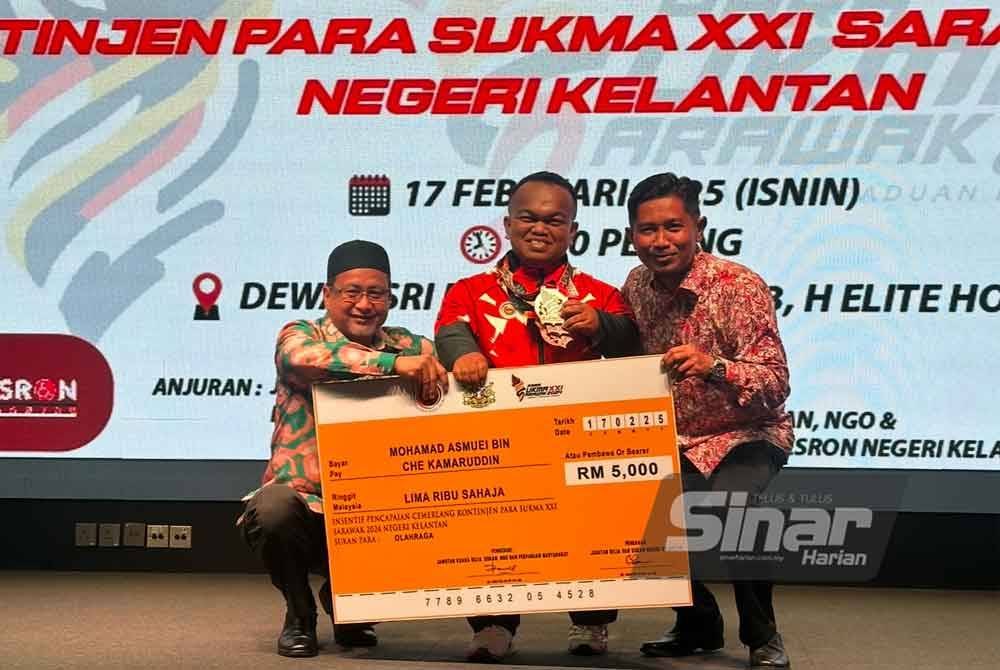 Mohamad Asmuei (tengah) menerima replika cek bernilai RM5,000 yang disampaikan oleh Zamakhshari (kiri). FOTO SINAR HARIAN-ADILA SHARINNI WAHID