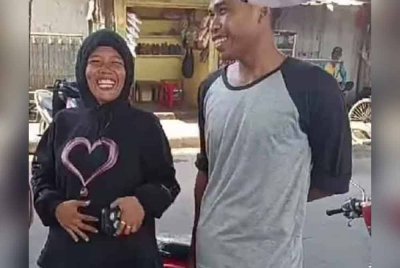 Wanita ini gembira selepas 'disaman' polis. - Agensi