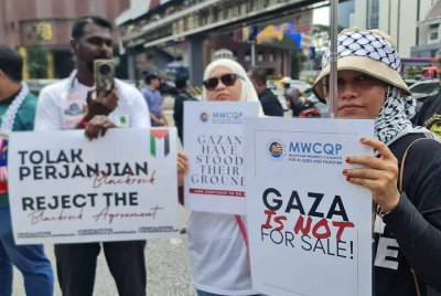Peserta Perhimpunan ‘Protes Plan Trump Usir Warga Gaza’ membawa plakad tanda desakan terhadap AS.