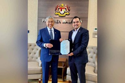 Asyraf Wajdi (kanan) menerima watikah pelantikan daripada Ahmad Zahid.