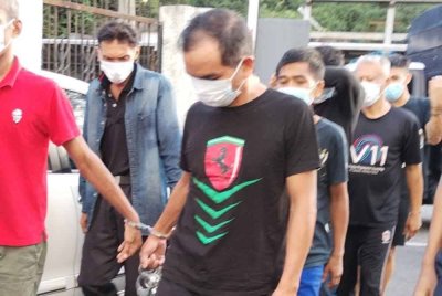 Tertuduh (hadapan, tengah), ketika tiba di Mahkamah pada Isnin.